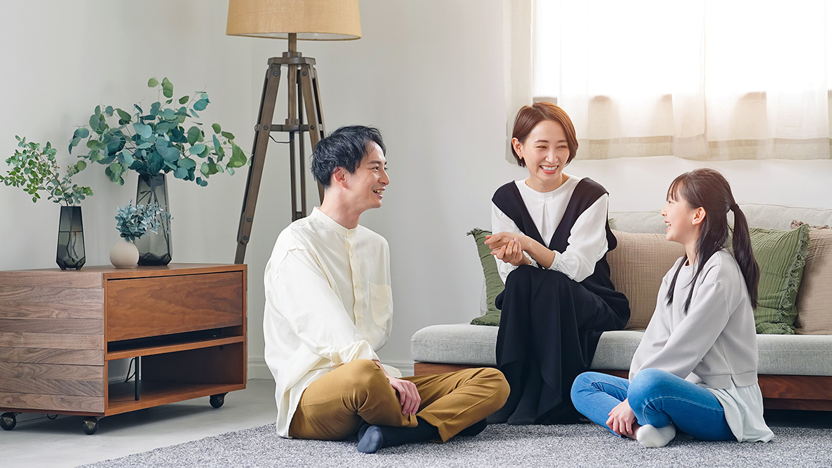 花粉対策をしたクリーンな室内で、床に座ってくつろぐ家族